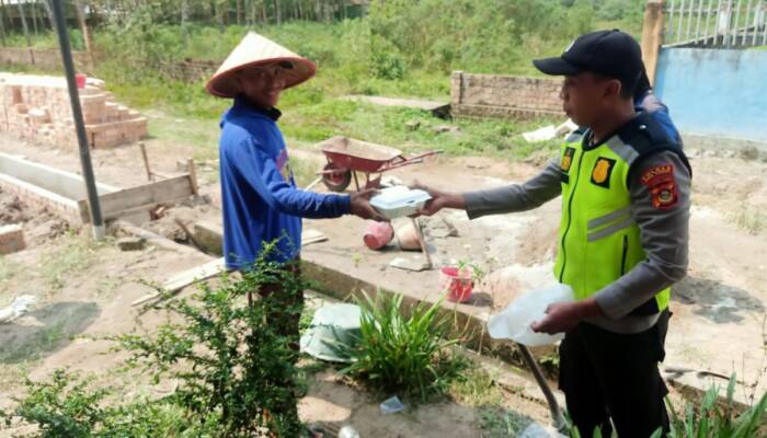 Anggota Polsek Belitang II Bagi Nasi Kotak Pada Masyarakat